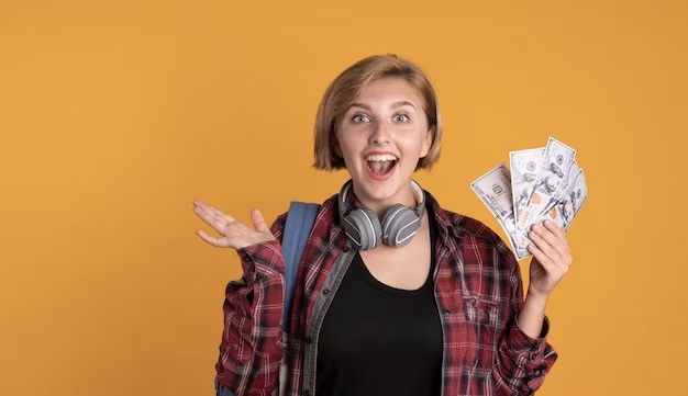 Female student with headphones and backpack holds money in her hand
