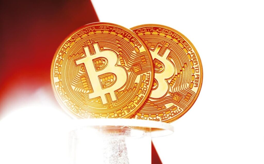 Two Bitcoin coins are superimposed with a bright, glowing backdrop