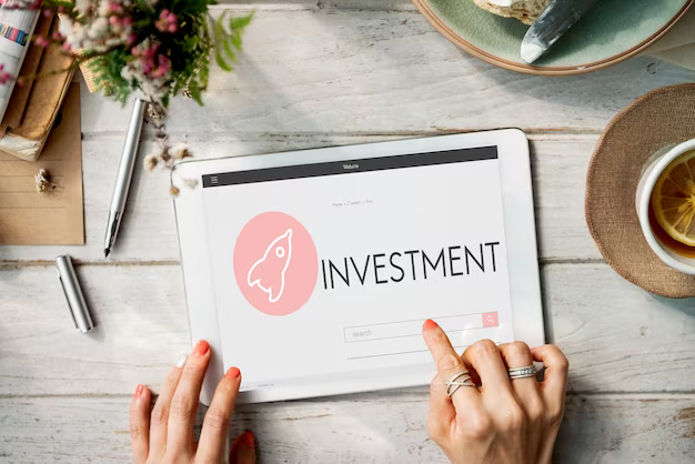 Finger on a tablet with the inscription investment